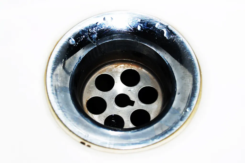 Desagüe cromado de lavatorio con gotas de agua